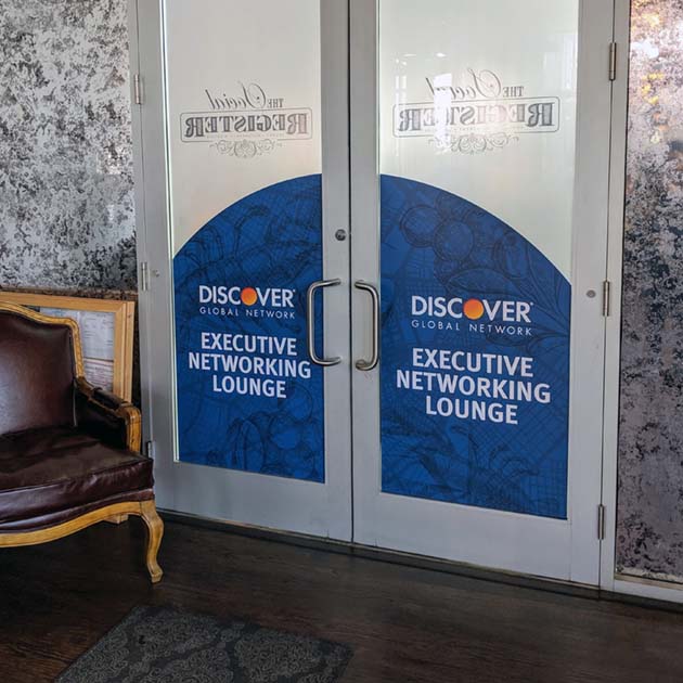 An image of adhesive vinyl window graphics marking the interior doors with the Discover logo and "Executive Networking Lounge"